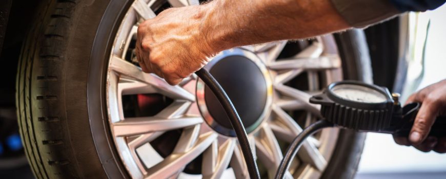 Mecánico midiendo la presión de los neumáticos para un correcto mantenimiento de las ruedas